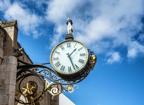 a clock on the side of a building with a statue on top at ibis Styles York Centre in York