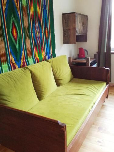 a couch with a green blanket on it in a room at Podołynia in Dwernik