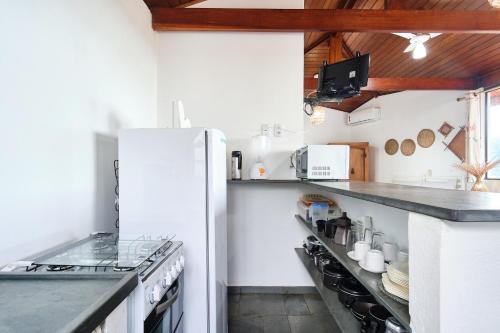 a kitchen with a white refrigerator and a counter at Chalés Mirante da Lagoinha in Ubatuba
