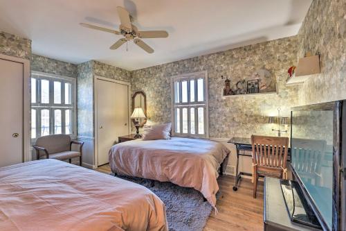 a bedroom with two beds and a desk with a fan at Cozy Kansas City Home with Yard - 9 Mi to Dtwn! in Kansas City