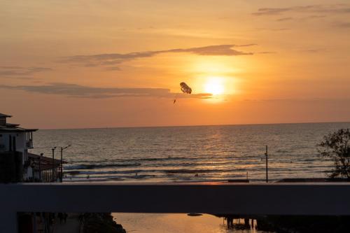 a kite flying over the ocean at sunset at Hotel Sol y Playa Montañita in Montañita