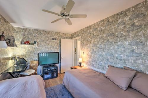 a bedroom with a bed and a flat screen tv at Cozy Kansas City Home with Yard - 9 Mi to Dtwn! in Kansas City