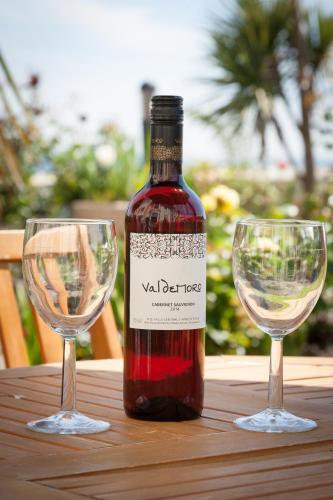 a bottle of wine and two wine glasses on a table at SGE Esplanade Hotel in Dunoon