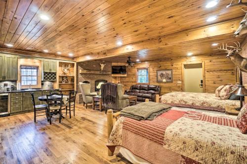 a log cabin bedroom with two beds and a kitchen at Walhonding Woods Secluded Farmland Retreat! in Walhonding