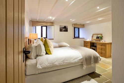 a bedroom with a bed and a desk and a mirror at Finest Retreats - Bretherdale Barn in Tebay