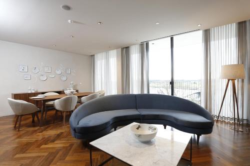 a living room with a blue couch and a table at Montebelo Vista Alegre Ílhavo Hotel in Ílhavo