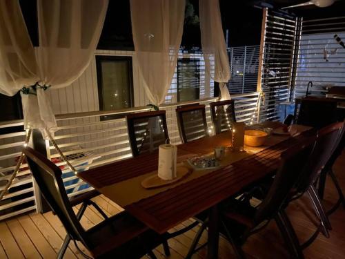 a wooden table with chairs in a dining room at Ahoi House 7 in Drage