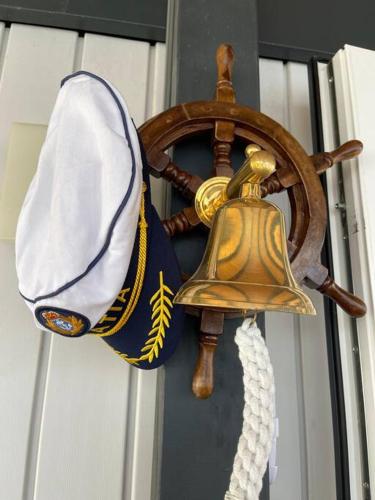 a bell and a hat hanging on a door at Ahoi House 7 in Drage