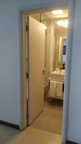 una puerta abierta a un baño con lavabo en Dpto de 1 dormitorio, 402 Dos Orillas, Colonia, en Colonia del Sacramento