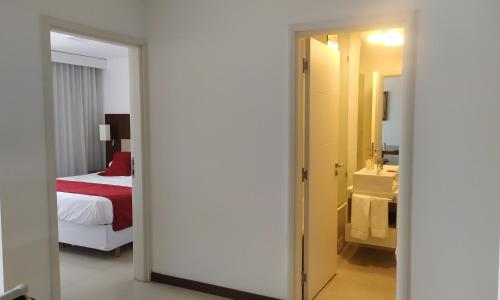 a hotel room with a bed and a bathroom at Apto Balcón Vista al Río Nª 402, Colonia del Sacramento in Colonia del Sacramento
