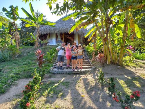 a group of people standing in front of a house at Magic Green Dentro del Parque Tayrona in El Zaino