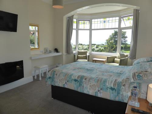 a bedroom with a bed and a large window at Bay Court in Bridlington