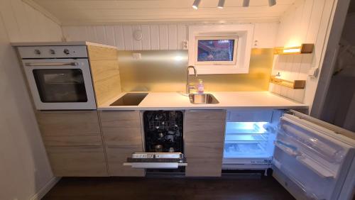 a small kitchen with a sink and a stove at Cabin magic on Senja, atmosphere like a fairytale in Botnhamn