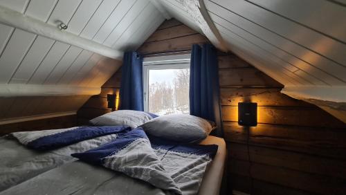 Ce lit se trouve dans une petite chambre dotée d'une fenêtre. dans l'établissement Cabin magic on Senja, atmosphere like a fairytale, à Botnhamn
