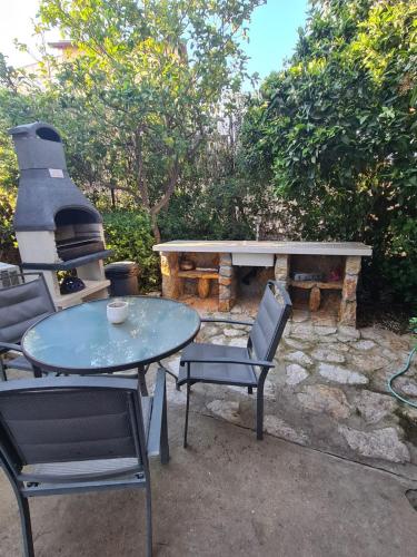 a patio with a table and chairs and a fireplace at la noach in Metulla