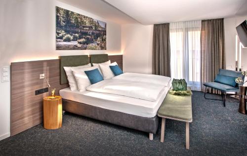 une chambre d'hôtel avec un lit et une chaise dans l'établissement Rose Bistro & Gästezimmer, à Altensteig