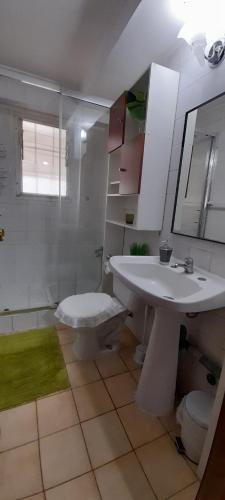 ein weißes Bad mit einem Waschbecken und einer Dusche in der Unterkunft Casa hospedaje Algarrobo-El Canelo in Algarrobo
