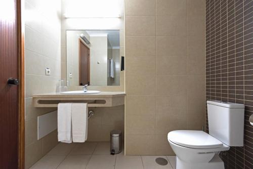 a bathroom with a toilet and a sink and a mirror at Bellavista Avenida By BeGuest in Albufeira