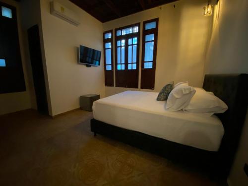 a bedroom with a large white bed and a window at Hotel Casa Bethel in Santa Marta