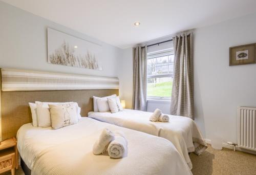 two beds in a hotel room with towels on them at Apartment 20 Inchmarlo in Banchory