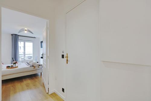 a white bathroom with a sink and a window at Buttes Chaumont - Sunny 2P apartment in Paris
