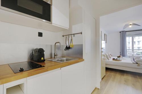 eine Küche mit einer Spüle und einer Arbeitsplatte in der Unterkunft Buttes Chaumont - Sunny 2P apartment in Paris