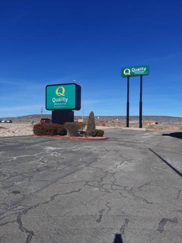 a gas station with two signs in the desert at Quality Inn & Suites Grants - I-40 in Grants