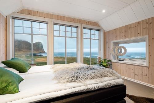a bedroom with a bed with a view of the ocean at Unstad Arctic Resort in Unstad