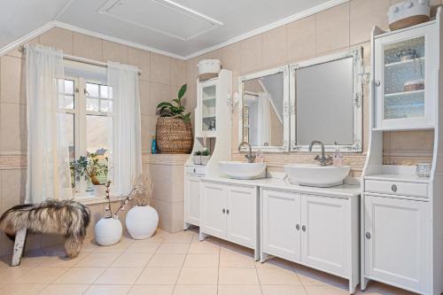 a bathroom with two sinks and two mirrors at Unstad Arctic Resort in Unstad