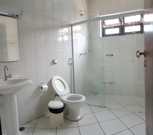 uma casa de banho com um chuveiro, um WC e um lavatório. em Casa Aconchego com PISCINA em Ubatuba