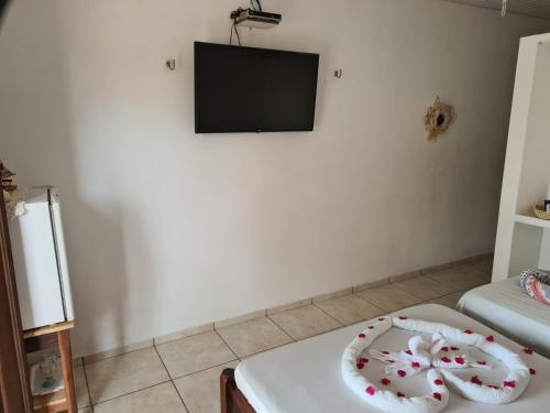 a living room with a television and a white table at Pousada Brilho da Lua in Trairi