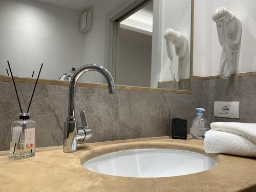 a bathroom counter with a sink and a mirror at La locanda di Geppetto in Bedollo