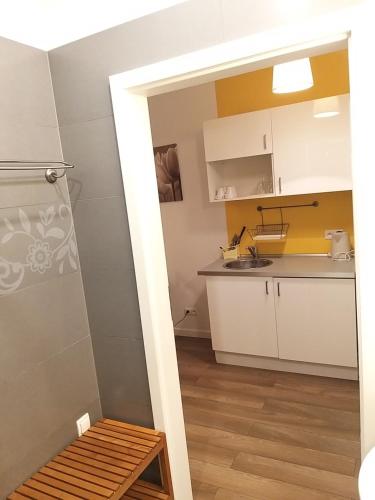 a small kitchen with white cabinets and a sink at Nowe Guty Fun in Nowe Guty