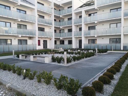 an external view of a building with a courtyard with plants at Apartament Piaskowy Sunset Resort in Grzybowo