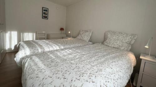 a bedroom with a bed with a white comforter at Chalet Buutengeweun, met luxe JACUZZI en TONSAUNA in Sint Annaland