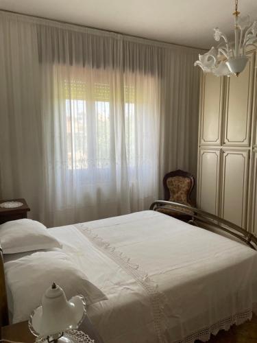 a bedroom with a white bed and a window at A casa di Zia Maria - Fuscaldoapartment in Fuscaldo