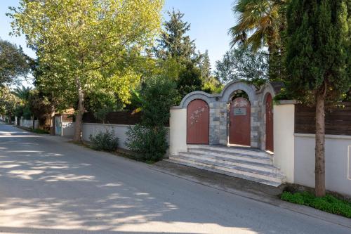 a house with a red door and stairs on a street at Villa Small Paradise private pool, jacuzzi, BBQ, complete privacy in Ialyssos
