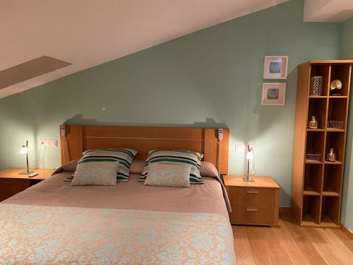 a bedroom with a large bed with two pillows at Apartamentos Alcañiz, Suite Deluxe in Alcañiz