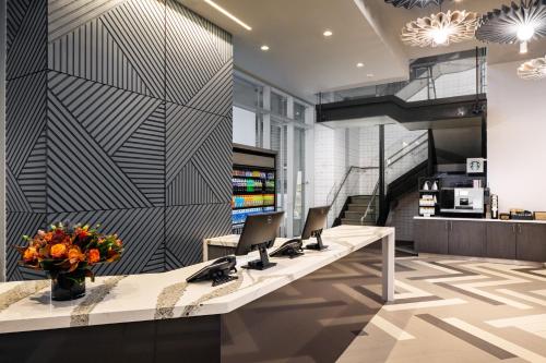 ニューヨークにあるHyatt Place New York Chelseaのノートパソコン2台が付いたフロントデスクのあるオフィス
