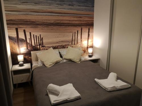a bedroom with a bed with two towels on it at Apartament Piaskowy Sunset Resort in Grzybowo