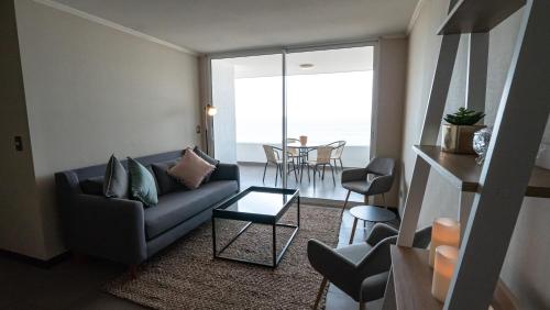 un salon avec un canapé et une table dans l'établissement Departamento frente al mar Iquique, à Iquique