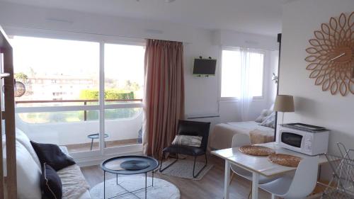 een hotelkamer met een bed, een tafel en een raam bij Studio vue panoramique sur mer in Villers-sur-Mer