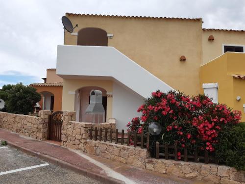 a house with a fence and flowers in front of it at Mare & Mirice - Case Appartamenti Vacanza in Aglientu