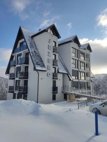 a building with snow in front of it at Apartmani Jezero Divčibare in Divčibare
