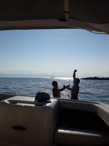 two people in a boat on the water at My Cool House in Porto Heli