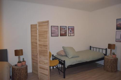 Cette chambre comprend un lit et une chaise. dans l'établissement Huis te Moerbeke-Waas, à Moerbeke