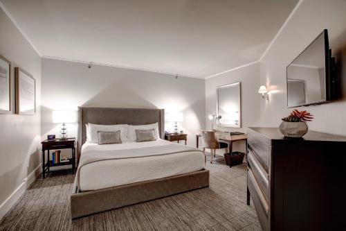 a bedroom with a large bed and a desk at The Woodmark Hotel & Still Spa on Lake Washington in Kirkland