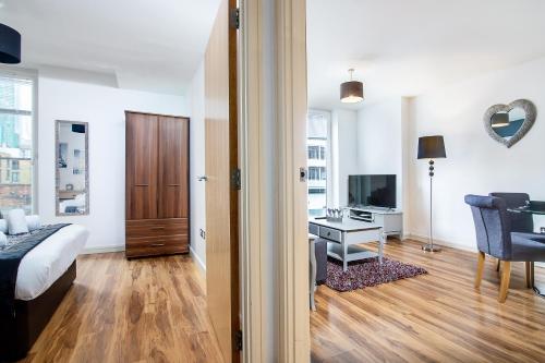 a bedroom with a bed and a room with a desk at Chinatown Birmingham Apartments in Birmingham