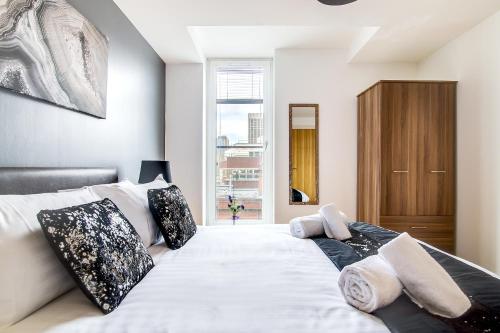 Un dormitorio con una gran cama blanca con almohadas. en Chinatown Birmingham Apartments, en Birmingham