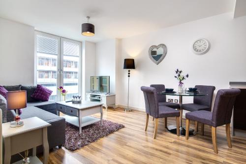 a living room with a couch and a table at Chinatown Birmingham Apartments in Birmingham